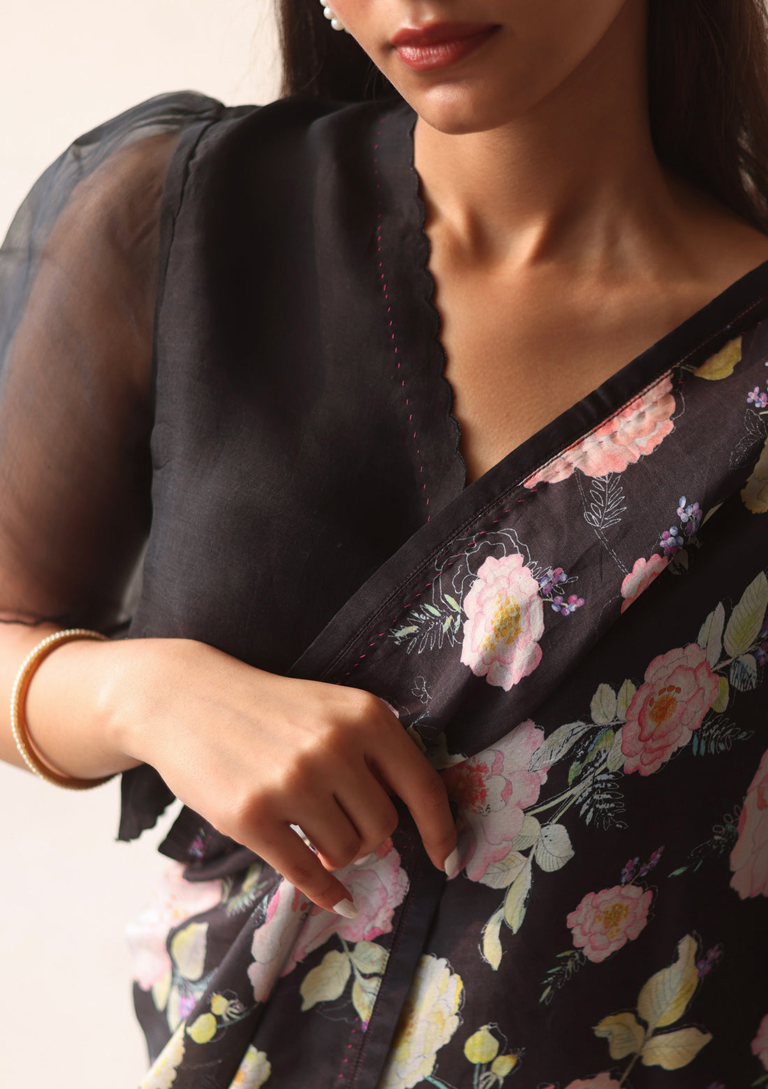 Black designer blouse, crafted in handwoven organza silk, from Surmaye. Scalloped embroidery edges all over. Lined with handwoven mulberry silk. Paired with Harmony Black floral saree.