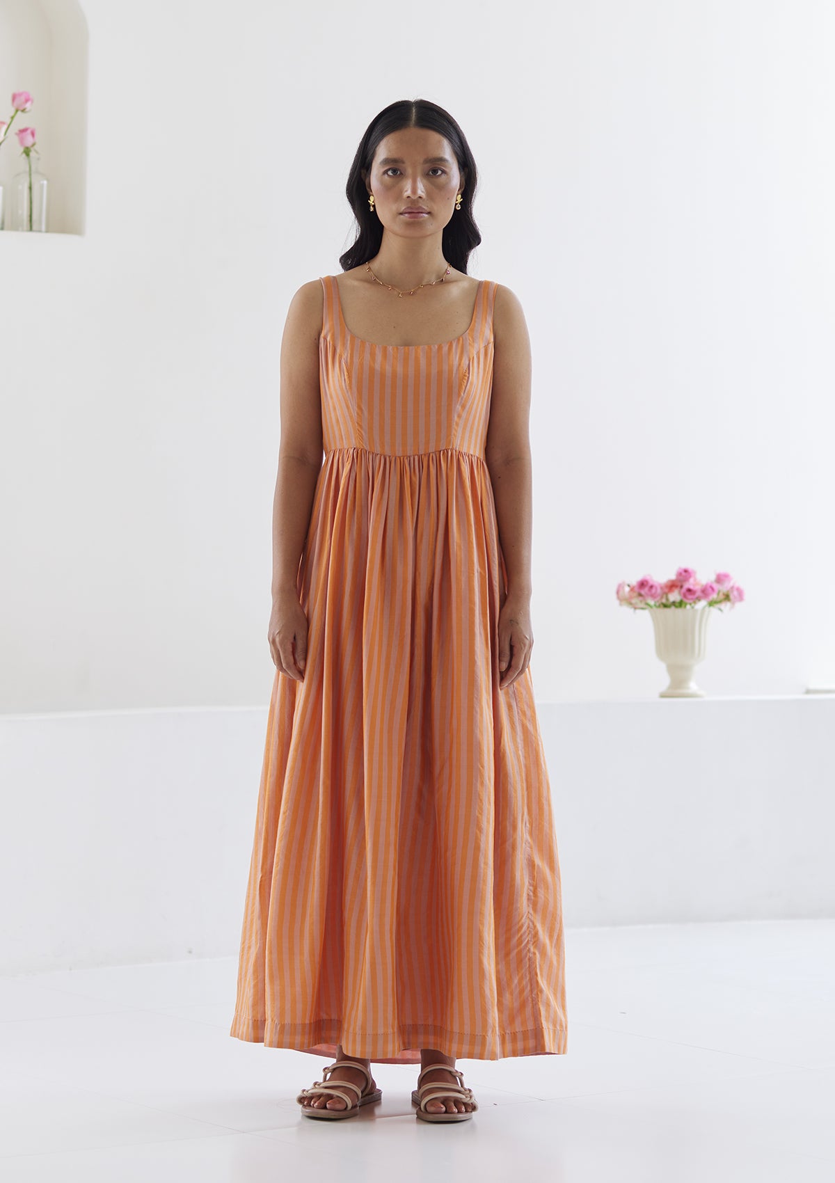 Handwoven maxi dress in silk modal, from Surmaye. Sleeveless dress in a fit-and-flare silhouette, with pink and orange stripes. Full view.