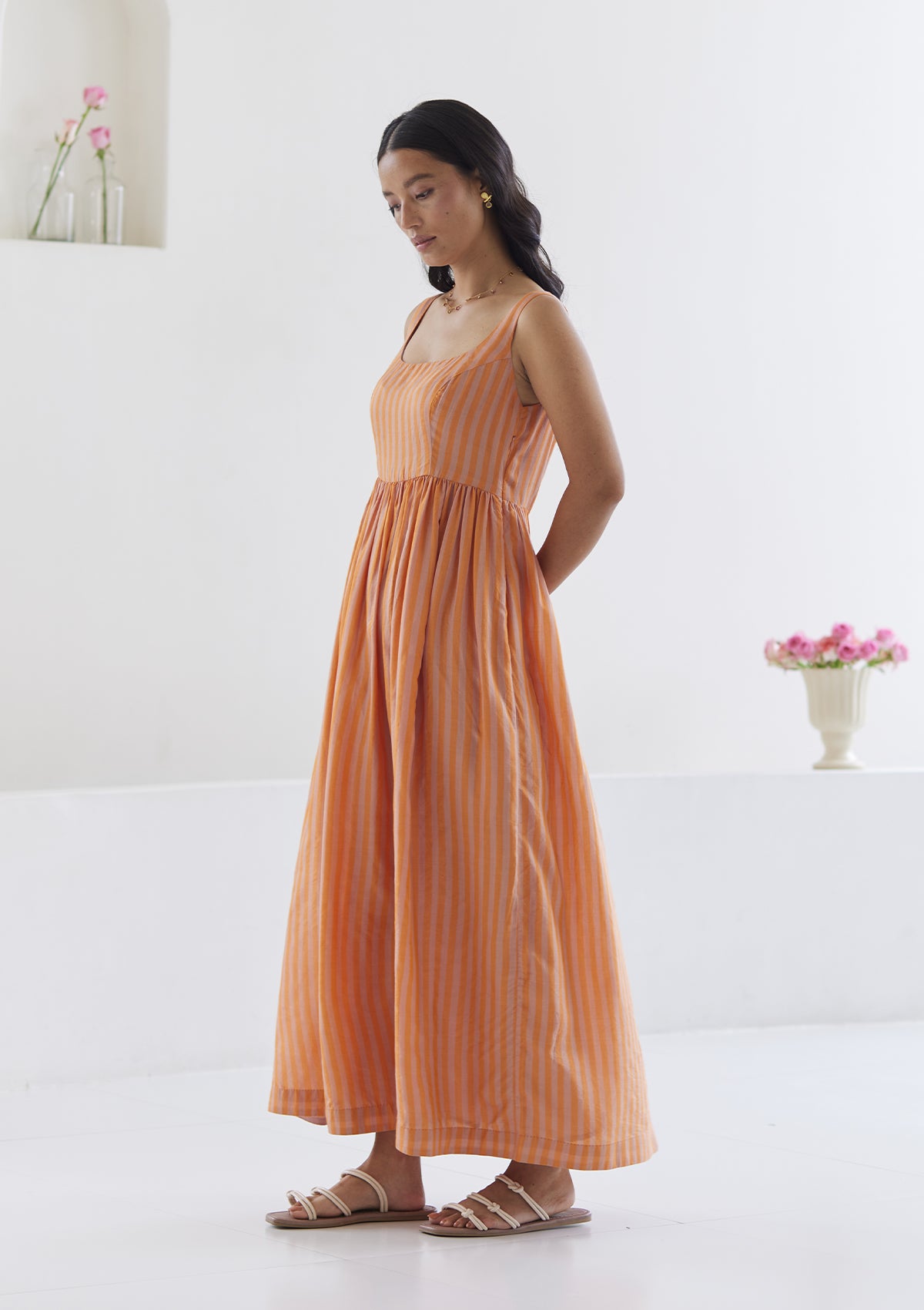 Handwoven maxi dress in silk modal, from Surmaye. Sleeveless dress in a fit-and-flare silhouette, with pink and orange stripes.