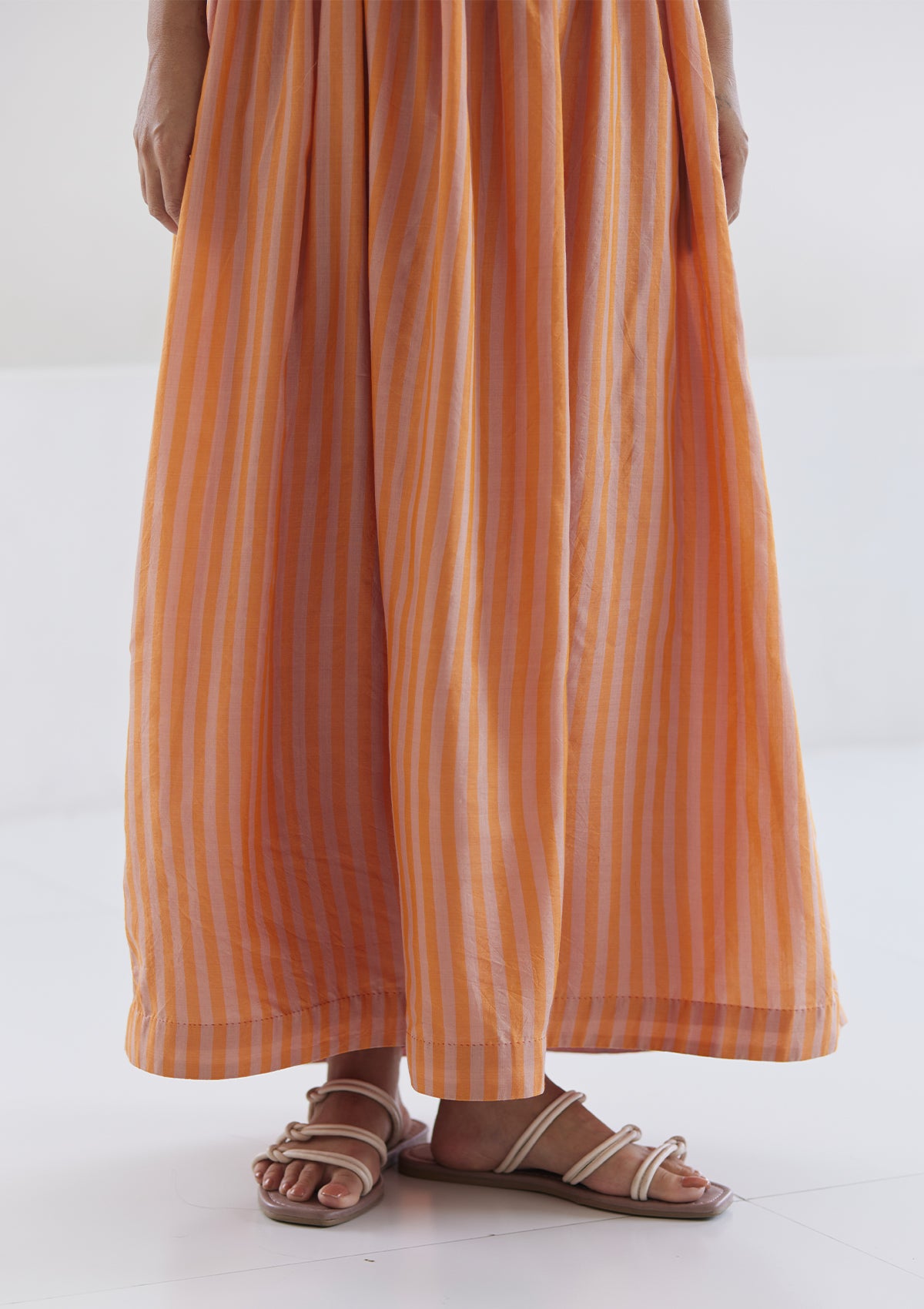 Handwoven maxi dress in silk modal, from Surmaye. Sleeveless dress in a fit-and-flare silhouette, with pink and orange stripes.