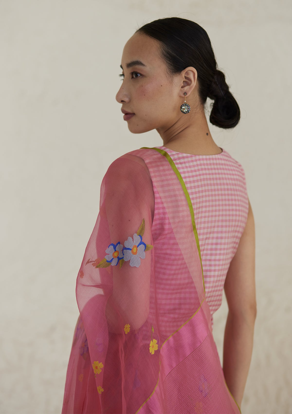 Handloom organza mulberry silk jamdani saree in carnation pink, from Surmaye. Intricate all-over floral motifs. Paired with designer blouse with pink gingham checks.