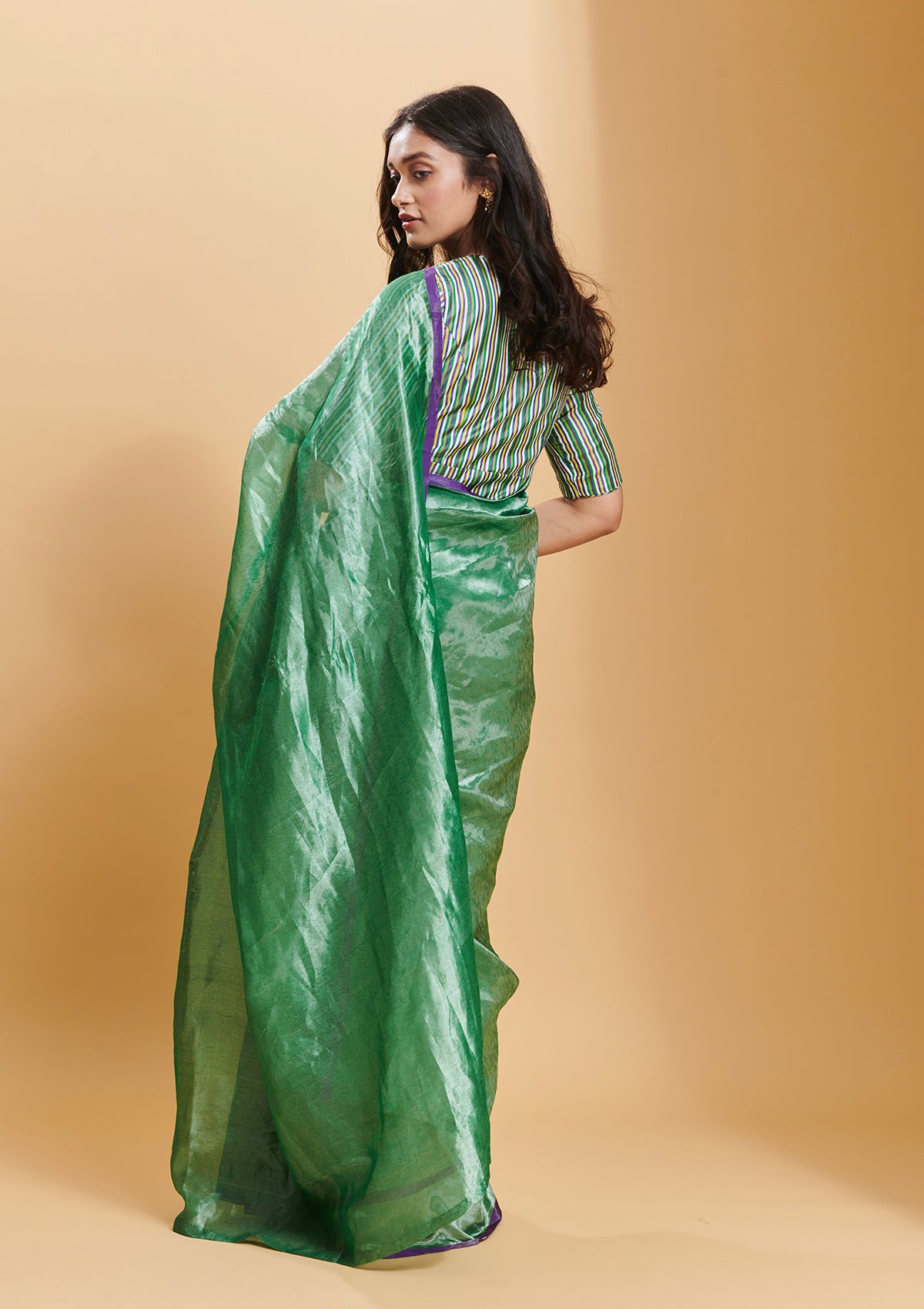 Green handloom saree from Surmaye, made with handwoven mulberry silk zari. Contrasting purple satin border.