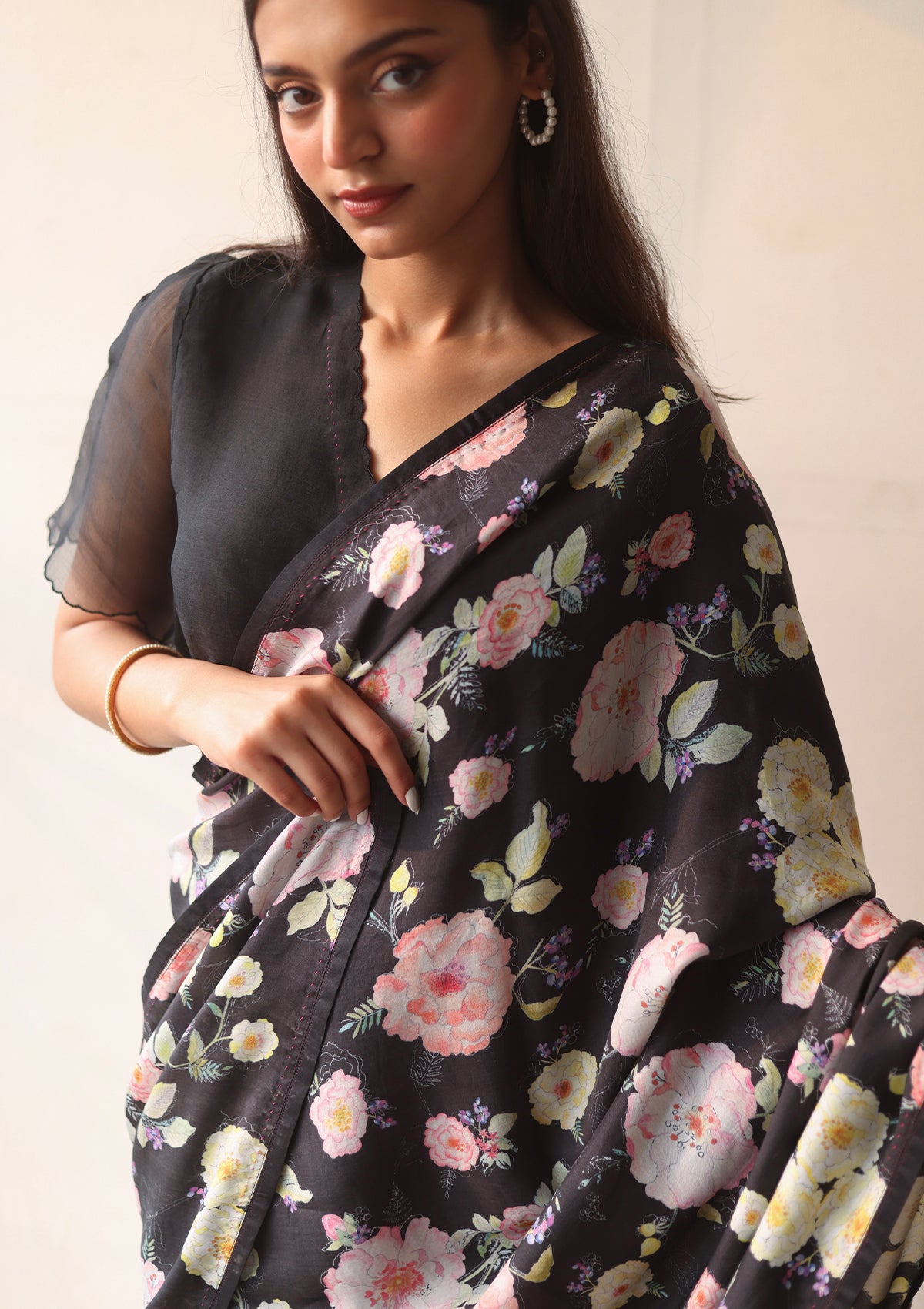 Handloom black saree from Surmaye, with hand-painted floral print on handwoven mulberry silk. Paired with black designer blouse, with scalloped embroidery edges all over.
