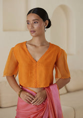 Orange designer blouse, crafted in handwoven organza silk, from Surmaye. Scalloped embroidery edges all over. Lined with handwoven mulberry silk.