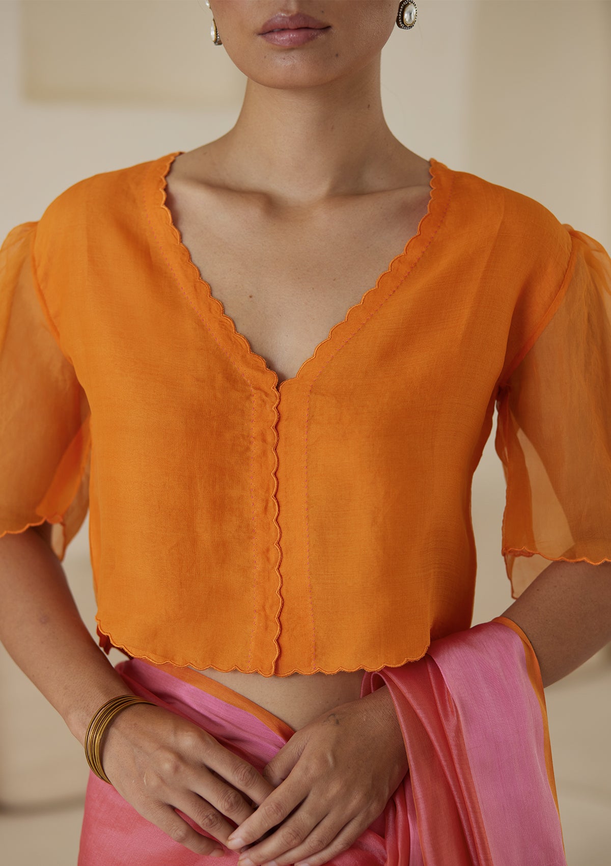 Orange designer blouse, crafted in handwoven organza silk, from Surmaye. Scalloped embroidery edges all over. Lined with handwoven mulberry silk.