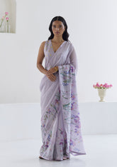 Handloom organza mulberry silk saree in mauve, from Surmaye. Intricate, hand-drawn, iris flower border print. Paired with mauve designer blouse in floral print.