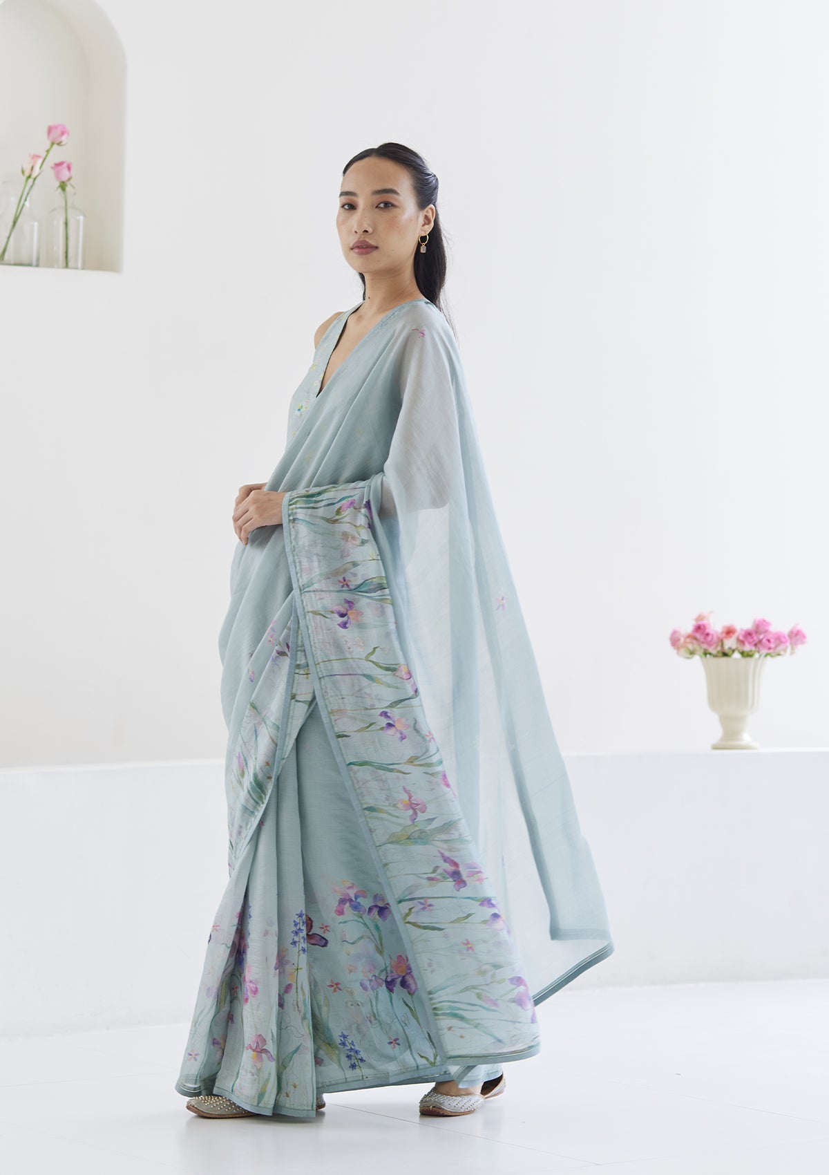 Handloom organza mulberry silk saree in seafoam, from Surmaye. Intricate, hand-drawn, iris flower border print. Paired with seafoam designer blouse in floral print.