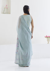 Handloom organza mulberry silk saree in seafoam, from Surmaye. Intricate, hand-drawn, iris flower border print. Paired with seafoam designer blouse in floral print.