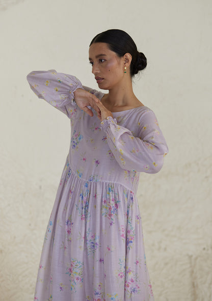 Floral mauve dress in silk modal, from Surmaye. All-over pansy print, handmade in watercolour. Round neckline, and a full sleeve ruched at the hem.