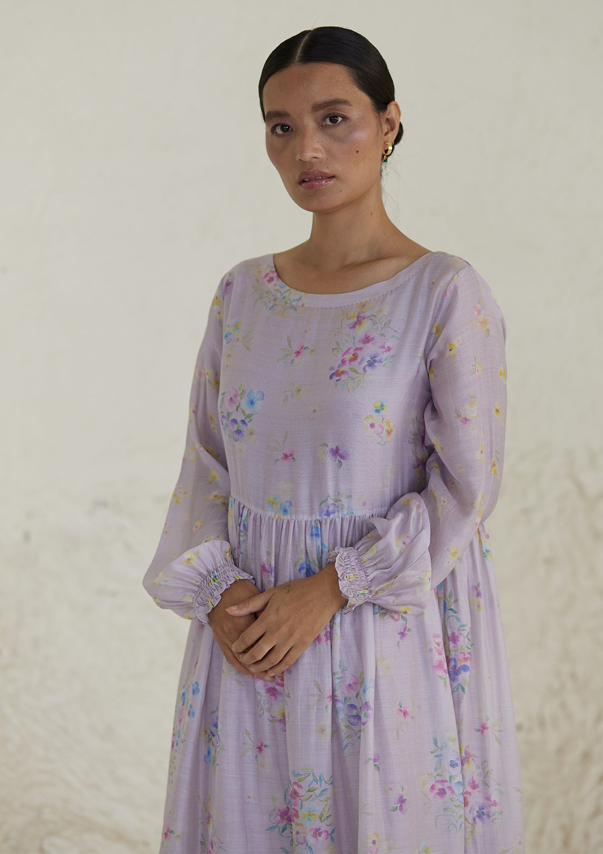 Floral mauve dress in silk modal, from Surmaye. All-over pansy print, handmade in watercolour. Round neckline, and a full sleeve ruched at the hem.