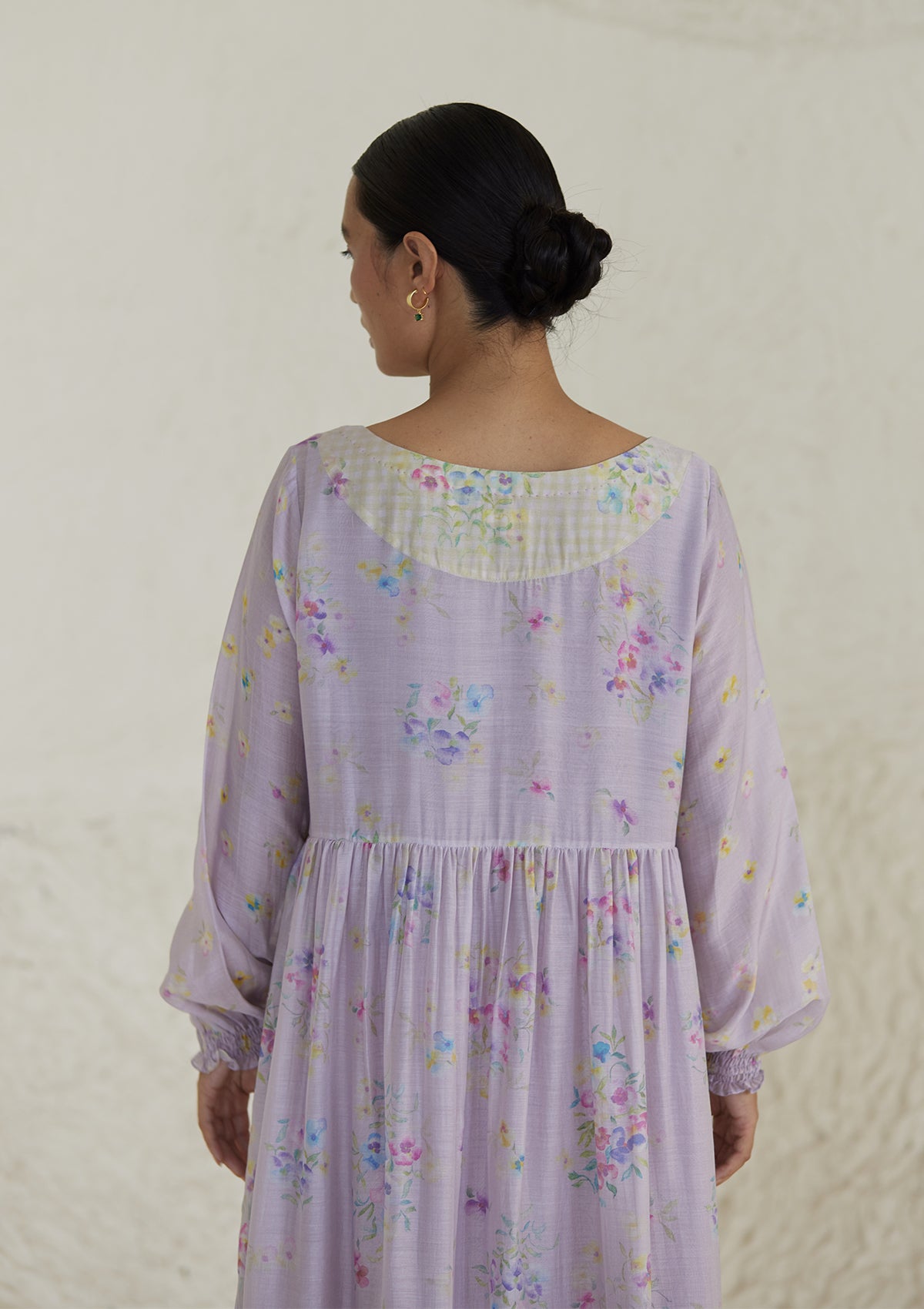 Floral mauve dress in silk modal, from Surmaye. All-over pansy print, handmade in watercolour. Round neckline, and a full sleeve ruched at the hem.