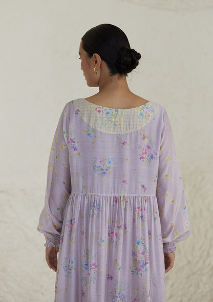 Floral mauve dress in silk modal, from Surmaye. All-over pansy print, handmade in watercolour. Round neckline, and a full sleeve ruched at the hem.