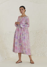 Floral pink dress in handwoven silk modal, from Surmaye. Ranunculus flower print, handmade in watercolour. Round neckline, and a full sleeve ruched at the hem.