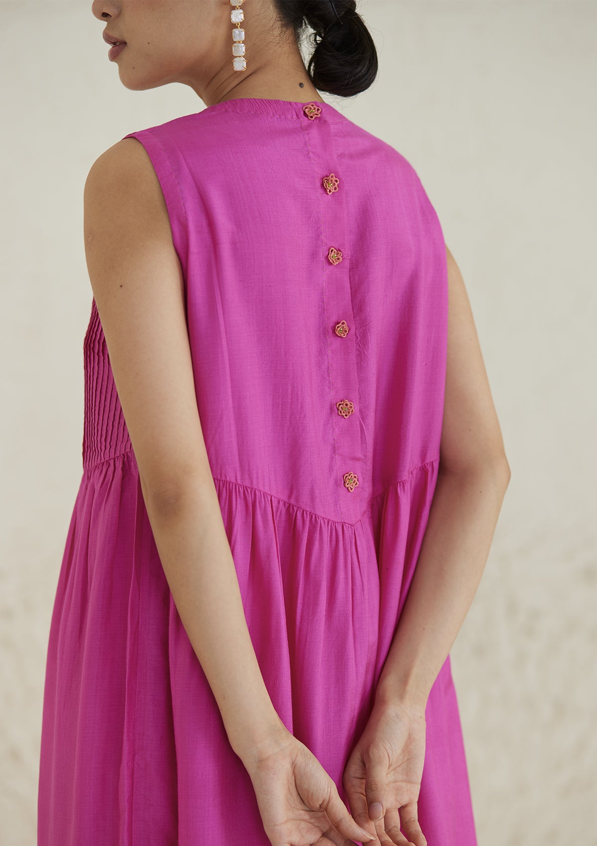 Pink silk dress from Surmaye, in handwoven silk modal. Exquisite pleat detailing on the front yoke, and handmade tatted flower buttons on the back yoke.