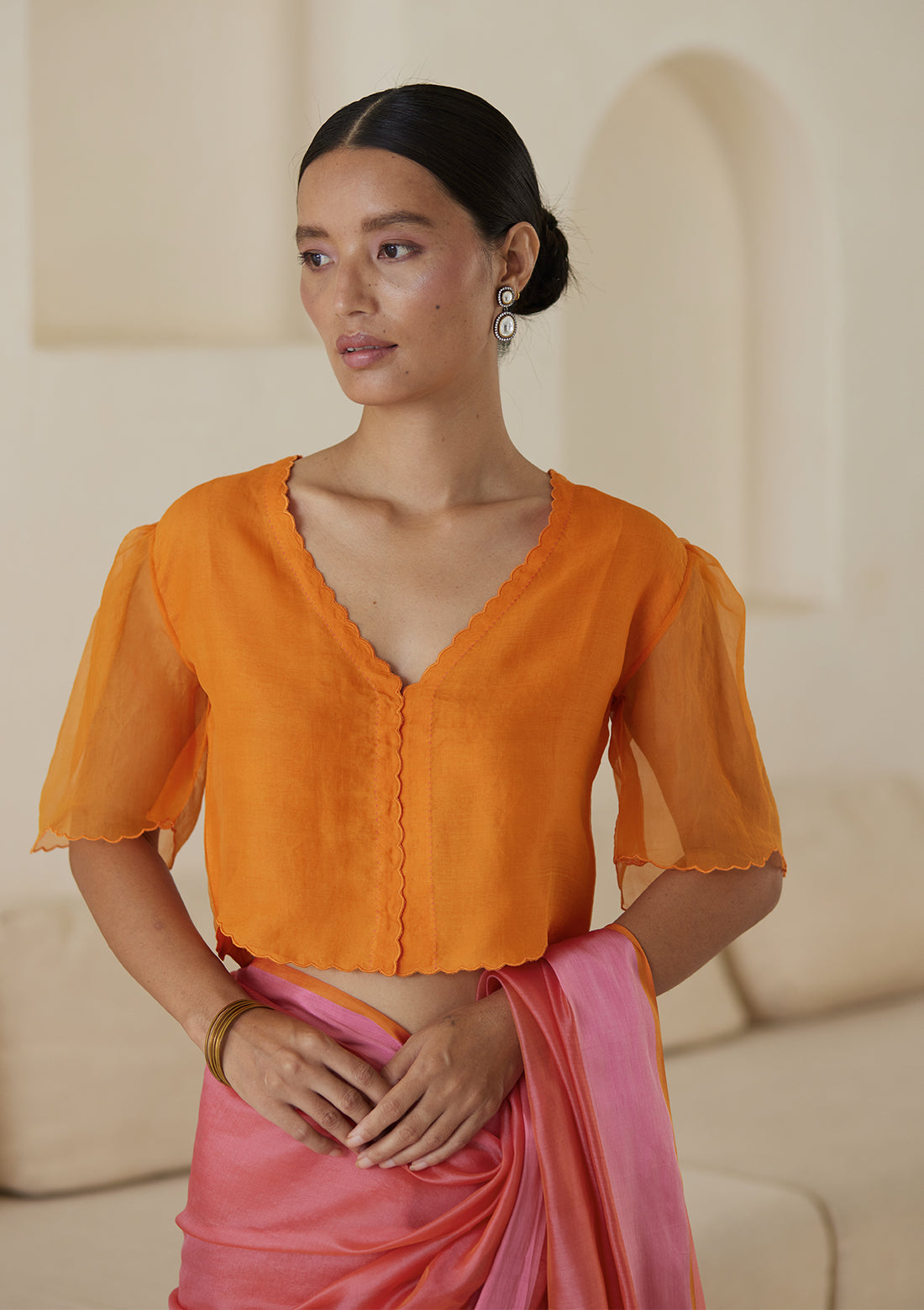 Orange designer blouse, crafted in handwoven organza silk, from Surmaye. Scalloped embroidery edges all over. Lined with handwoven mulberry silk.