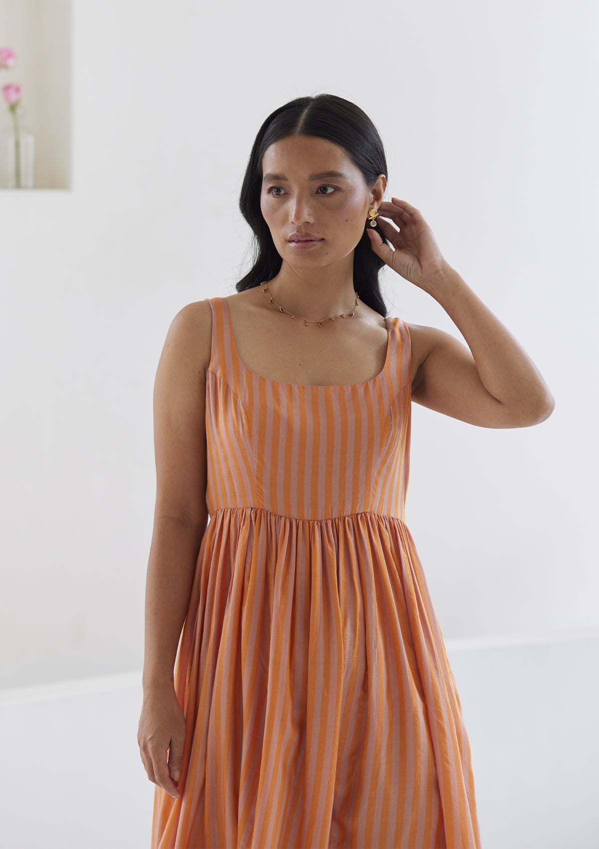 Handwoven maxi dress in silk modal, from Surmaye. Sleeveless dress in a fit-and-flare silhouette, with pink and orange stripes. 