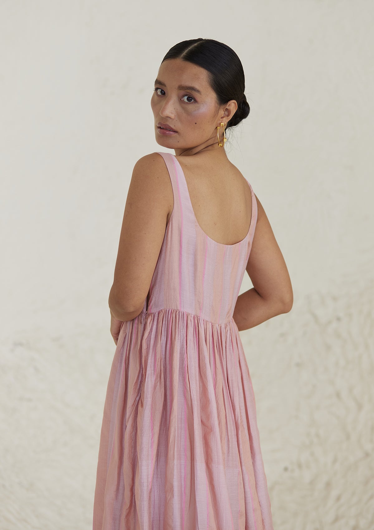 Handwoven maxi pink dress in silk modal, from Surmaye. Sleeveless dress in a fit-and-flare silhouette, with dual-toned pink stripes. Back view