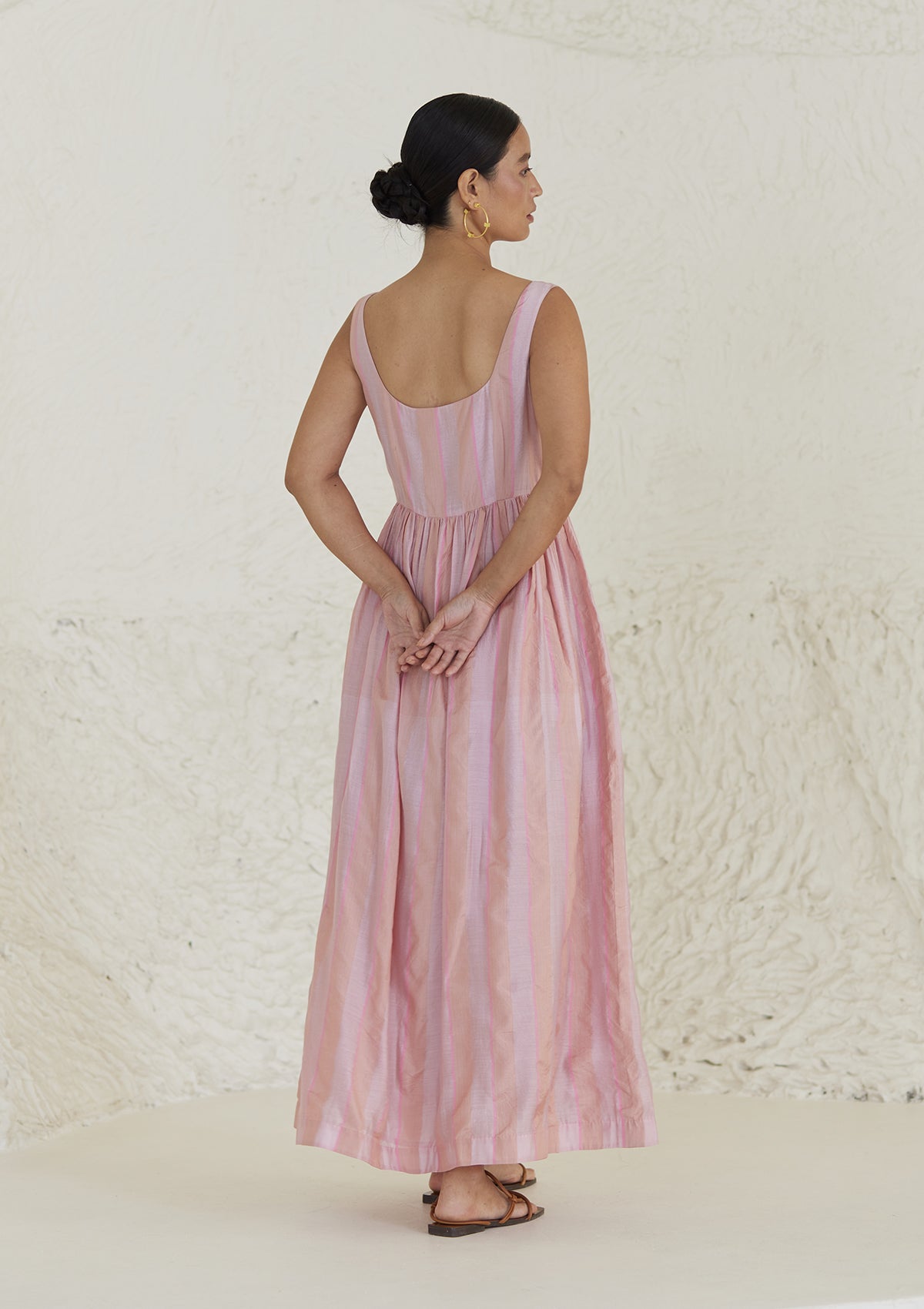 Handwoven maxi pink dress in silk modal, from Surmaye. Sleeveless dress in a fit-and-flare silhouette, with dual-toned pink stripes. Back view