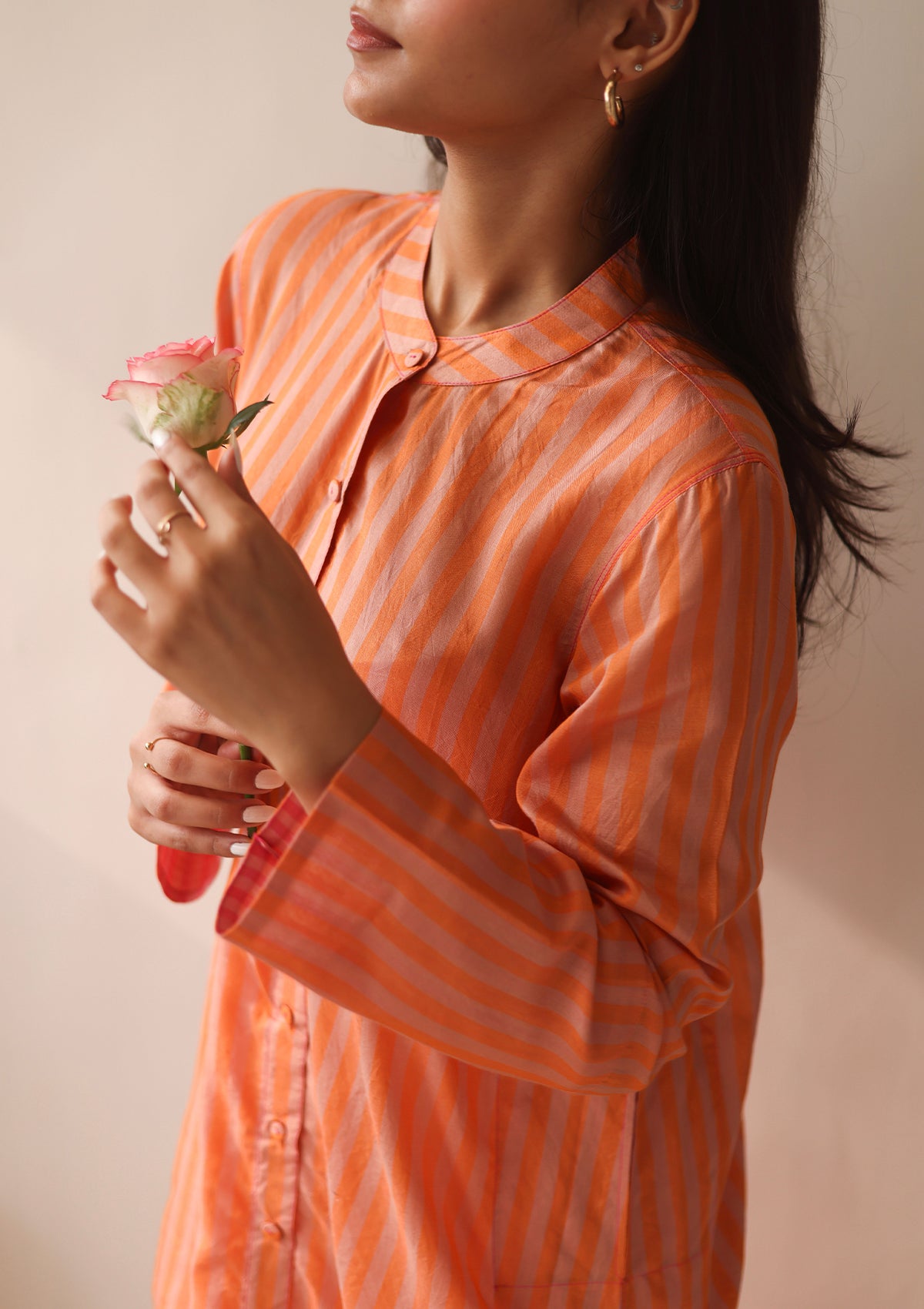 Kurta set for women, in orange stripes, from Surmaye. Made in handwoven silk modal with a relaxed silhouette. Vibrant contrast-pink checked fabric detailing.