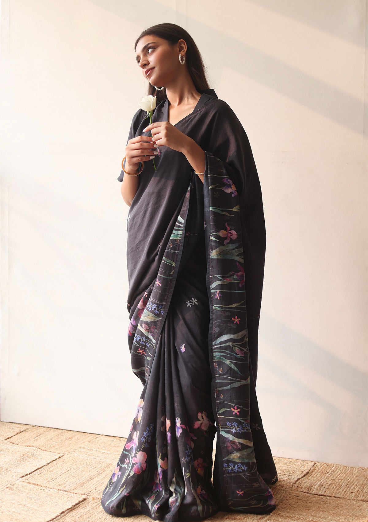 Handloom organza mulberry silk saree in black, from Surmaye. Intricate, hand-drawn, iris flower border print. Paired with black collar blouse.