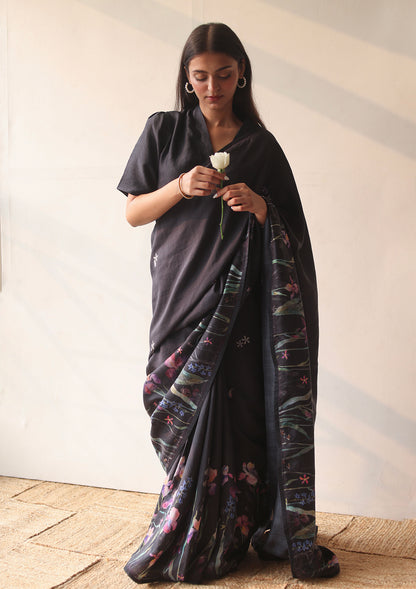 Handloom organza mulberry silk saree in black, from Surmaye. Intricate, hand-drawn, iris flower border print. Paired with black collar blouse.