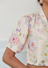 Designer blouse from Surmaye in champagne colour, made with handwoven mulberry silk. Hand-drawn floral print and a collared shirt silhouette. Close-up of floral print