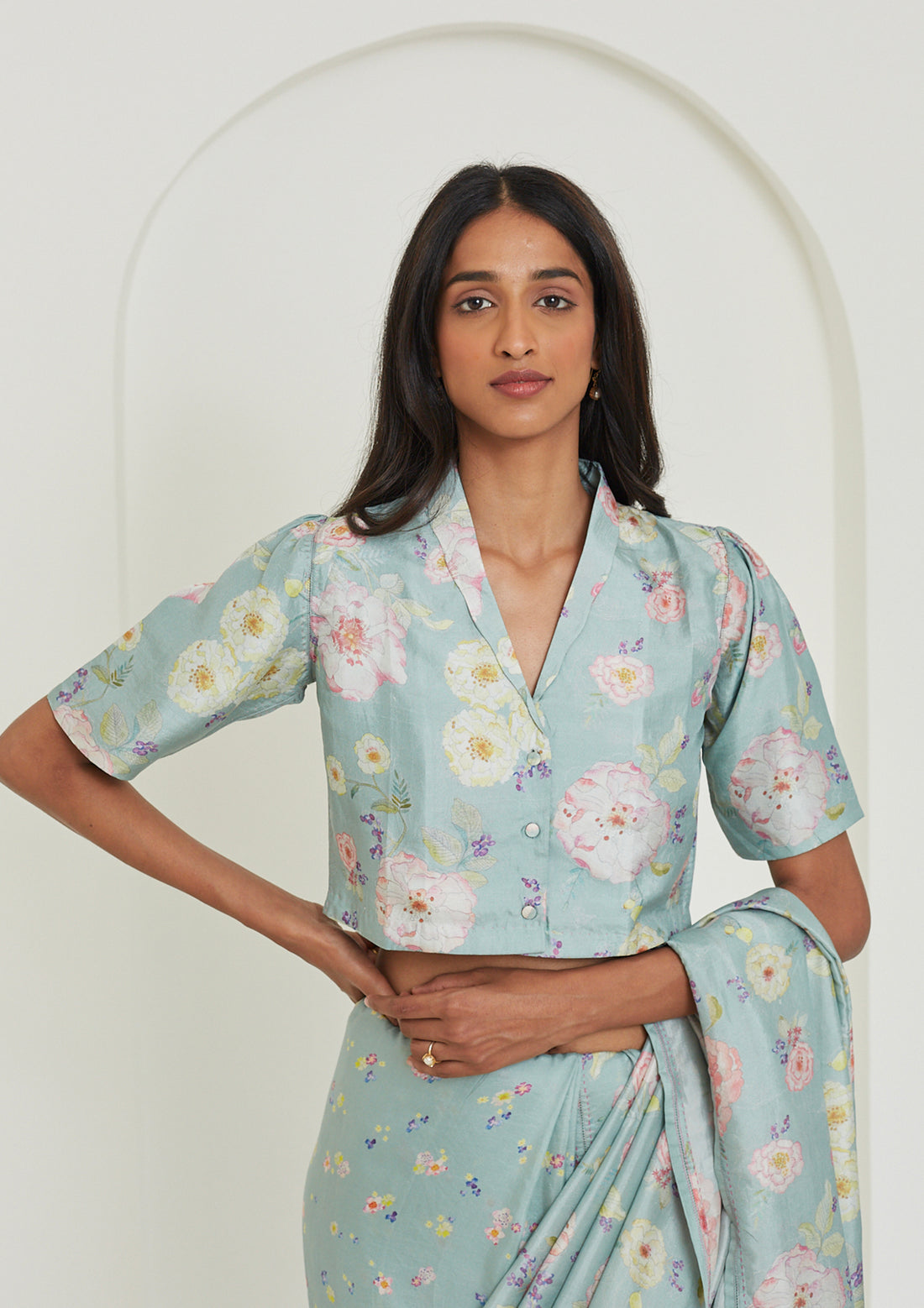 Designer blouse from Surmaye in sage green colour, made with handwoven mulberry silk. Hand-drawn floral print and a collared shirt silhouette.