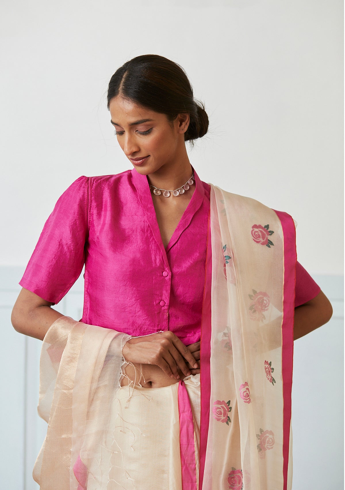 Handloom silk organza jamdani saree, from Surmaye. Intricate rose motifs, woven with silk yarns, on champagne hue of the saree. Paired with a pink designer collar-shirt style blouse.