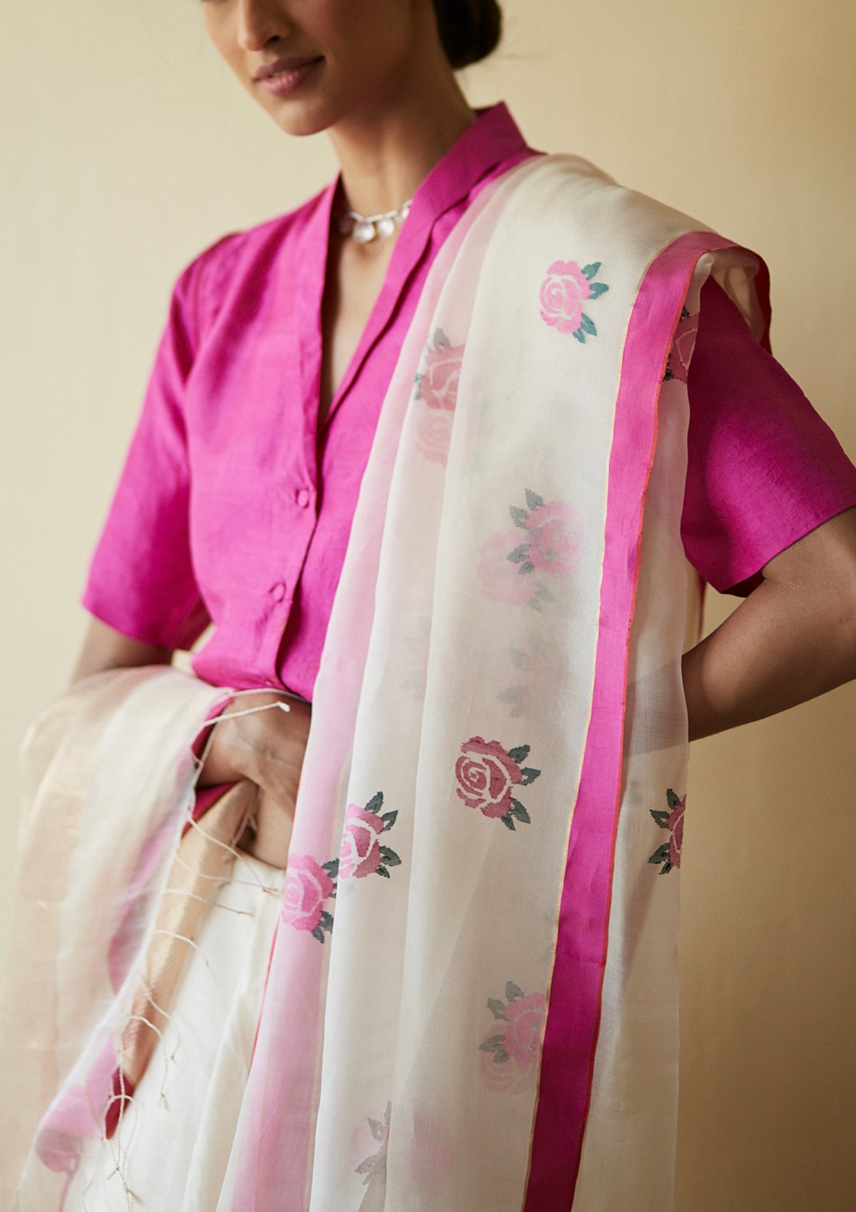 Handloom silk organza jamdani saree, from Surmaye. Intricate rose motifs, woven with silk yarns, on champagne hue of the saree. Paired with a pink designer collar-shirt style blouse.