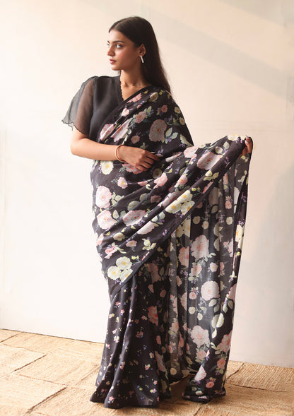 Handloom black saree from Surmaye, with hand-painted floral print on handwoven mulberry silk. Paired with black designer blouse, with scalloped embroidery edges all over. Full view