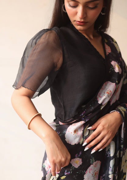 Black designer blouse, crafted in handwoven organza silk, from Surmaye. Scalloped embroidery edges all over. Paired with handloom black floral saree.